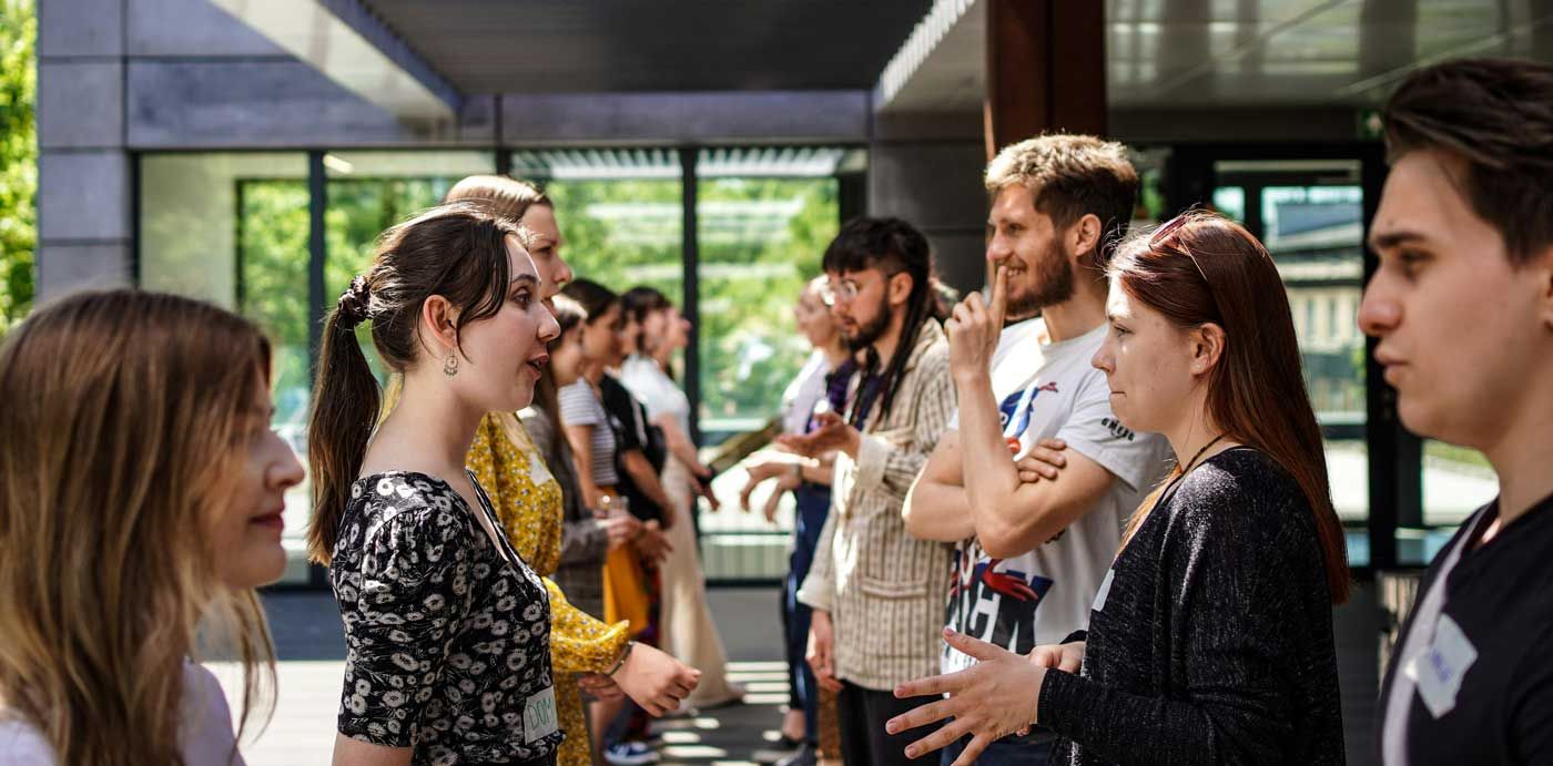 Das Bild zeigt eine Gruppe junger Erwachsener in ungezwungener Atmosphäre